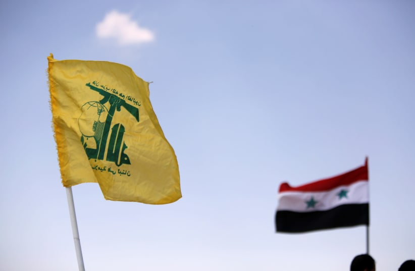 Hezbollah and Syrian flags are seen fluttering in Fleita, Syria August 2, 2017 (photo credit: OMAR SANADIKI/REUTERS)