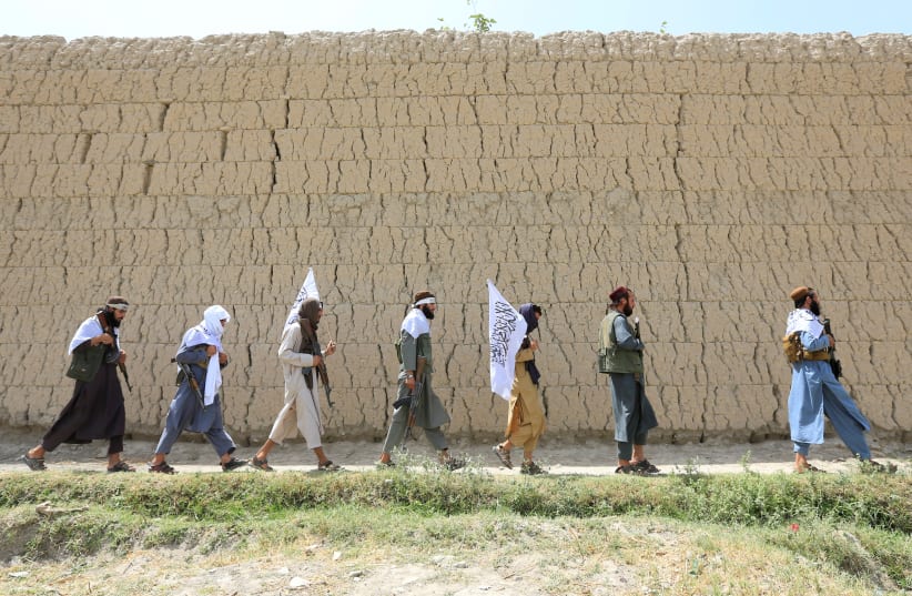 Taliban walk as they celebrate ceasefire in Ghanikhel district of Nangarhar province, Afghanistan  (photo credit: PARWIZ PARWIZ/REUTERS)