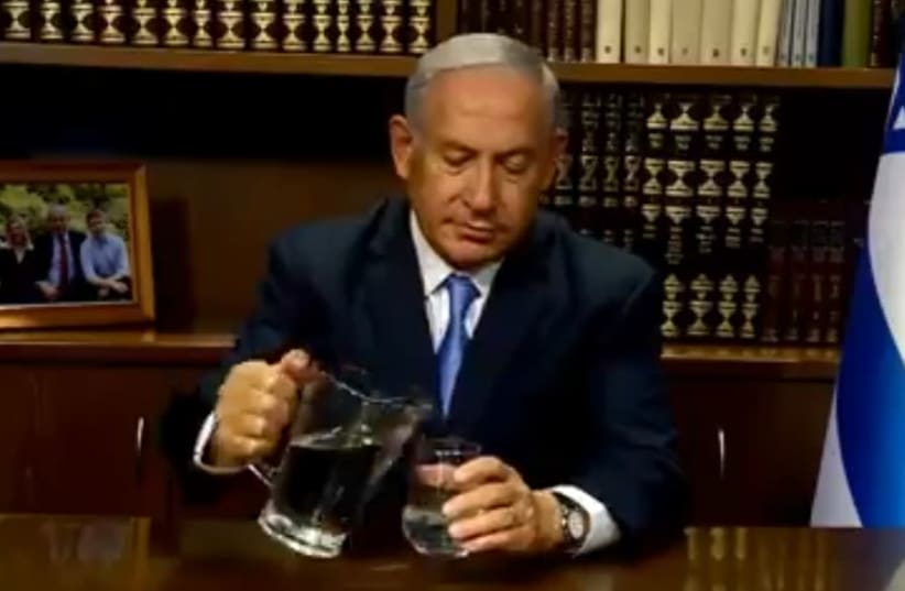 Prime Minister Benjamin Netanyahu pouring water during a video aimed at the people of Iran.   (photo credit: screenshot)