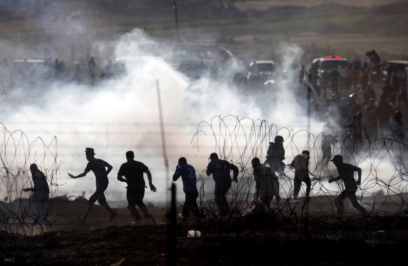 Palestinians protesting on the Gaza side of the border between Israel and Gaza, June 2018 (photo credit: AMIR COHEN/REUTERS)