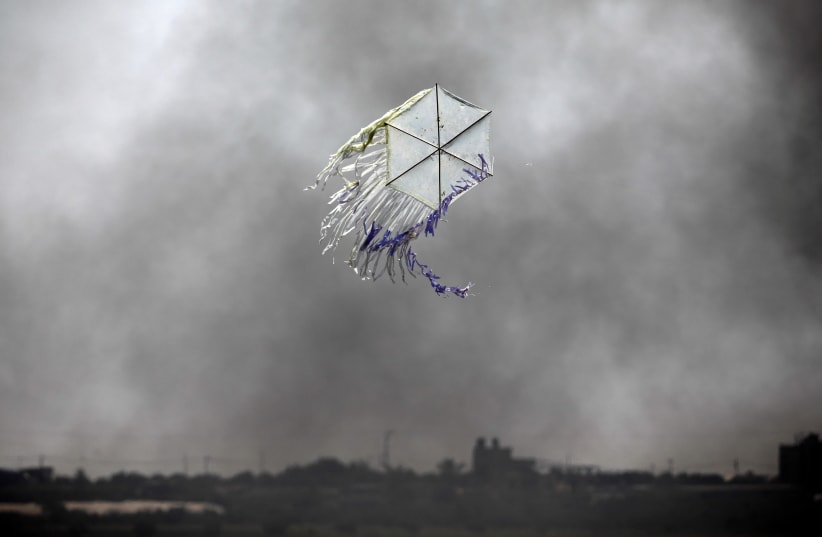 A kite flies over the border in an area where kites and balloons have caused blazes, between Israel and the Gaza strip June 8, 2018.  (photo credit: AMIR COHEN - REUTERS)