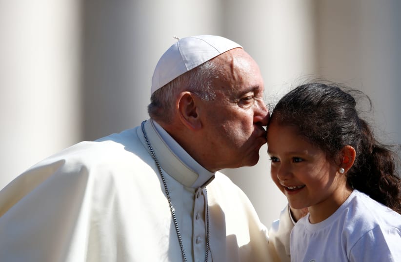 Pope Francis kisses a child during the Wednesday general audience in Saint Peter's square at the Vatican, June 20, 2018.  (photo credit: STEFANO RELLANDINI/REUTERS)