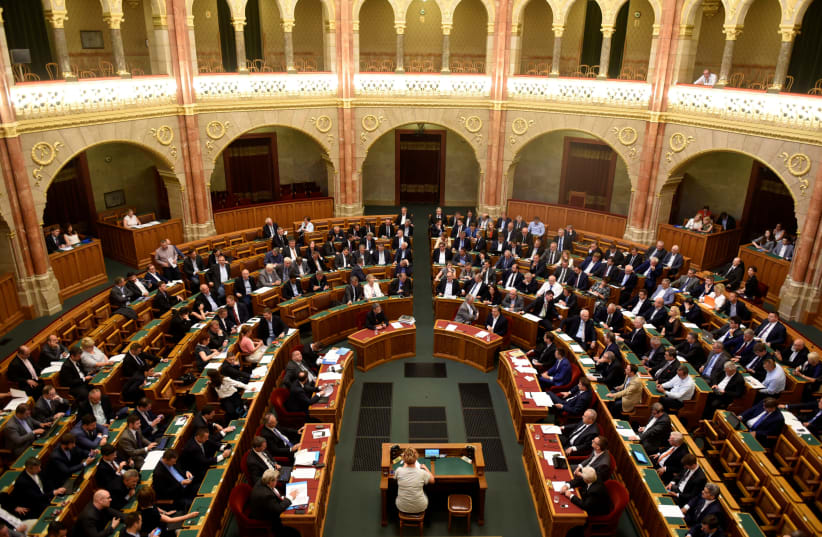 Members of the Hungarian government vote on the 'Stop Soros' package of bills that criminalises some help given to illegal immigrants, at the Parliament in Budapest, Hungary (photo credit: TAMAS KASZAS/REUTERS)