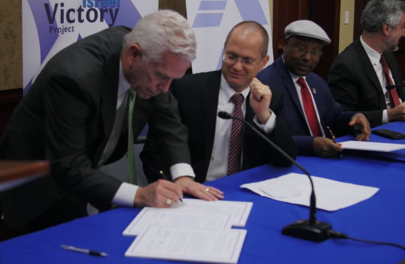 CONGRESSMAN BILL JOHNSON, one of the co- chairs of the Congressional Israel Victory Caucus,  signs the joint declaration with Knesset Israel Victory Caucus co-chairs MKs Oded Forer and Avraham Neguise, and Prof. Daniel Pipes (in the background), at a joint meeting of the CIVC and the KIVC in Congres (photo credit: Courtesy)
