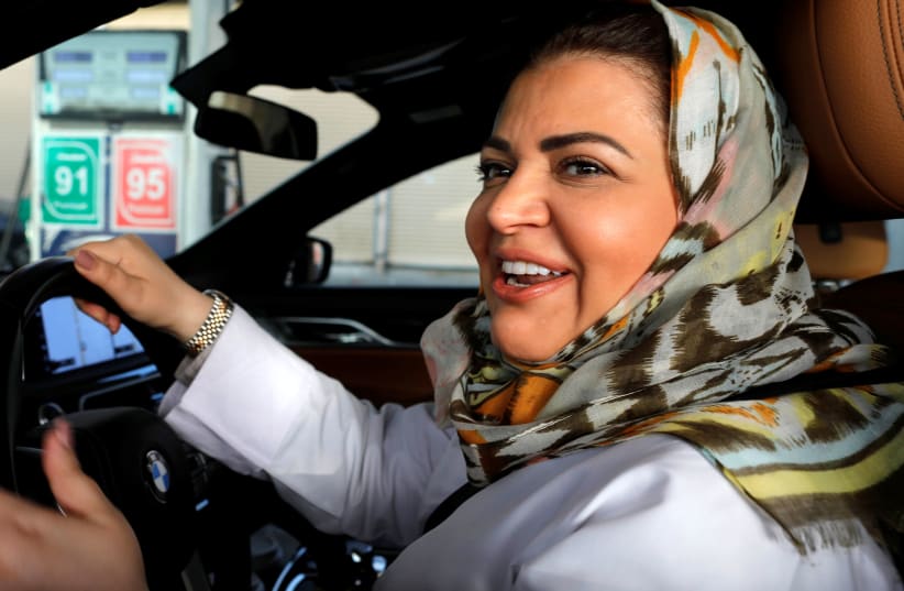 Samira al-Ghamdi, a practicing psychologist, smiles while making a stop to refuel her car as she drives to work in Jeddah, Saudi Arabia June 24, 2018. (photo credit: ZOHRA BENSEMRA/REUTERS)