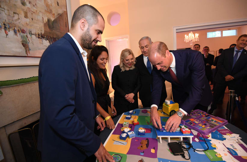 Prince William tries out AlgoBrix CTO's programming tool which turns computer coding into playing with Legos at an event Tuesday night centered around Israeli innovation.  (photo credit: HAIM ZACH/GPO)