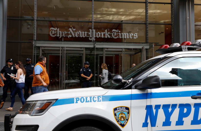 New York Police officers are seen deployed outside the New York Times building following a fatal shooting at a Maryland newspaper, in New York City, U.S., June 28, 2018.  (photo credit: BRENDAN MCDERMID/REUTERS)