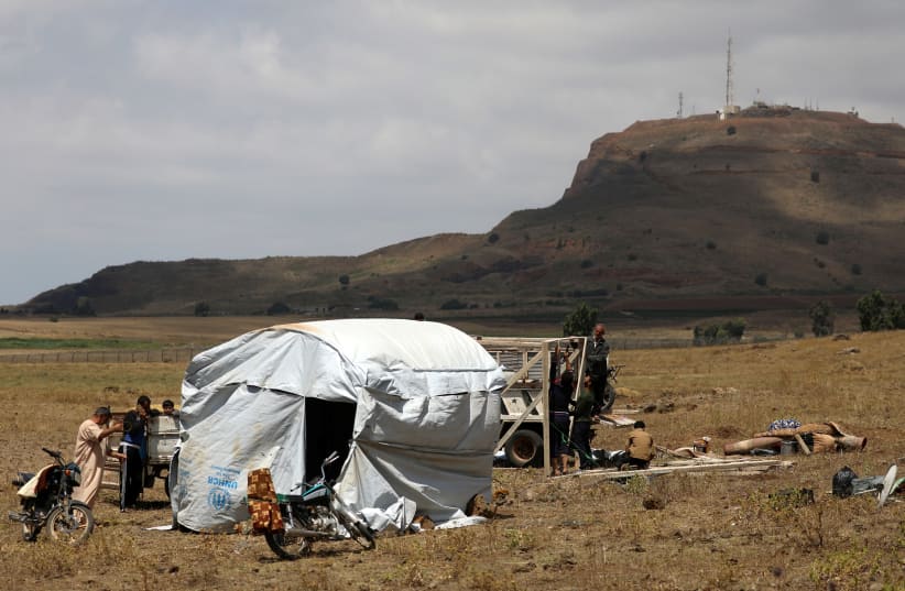 Internally displaced people from Deraa province erect a tent near the Golan Heights in Quneitra, Syria June 29, 2018 (photo credit: REUTERS/ALAA AL-FAQIR)