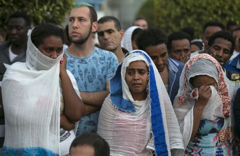 Israelis and fellow community members attend a memorial ceremony for Habtom Zarhum, an Eritrean migrant who was mistaken for a gunman at a shooting attack, in Tel Aviv, Israel October 21, 2015. (photo credit: REUTERS/BAZ RATNER)
