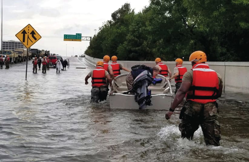 TEXAS ARMY National Guard soldiers move through flooded Houston streets as floodwaters from Hurricane Harvey rise, on August 28, 2017 (photo credit: Wikimedia Commons)