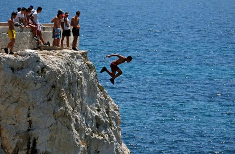 A teenager dives into the Mediterranean Sea (photo credit: REUTERS/JEAN-PAUL PELISSIER)