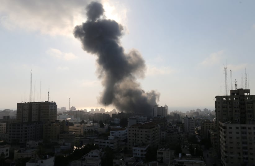 Smoke rises following an Israeli strike on a building in Gaza City July 14, 2018 (photo credit: REUTERS/IBRAHEEM ABU MUSTAFA)