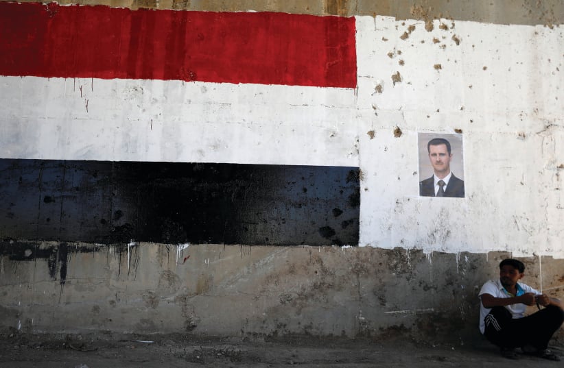 ON THE march. A poster of Syrian dictator Bashar Assad who is allied with Russia and Iran.  (photo credit: REUTERS)