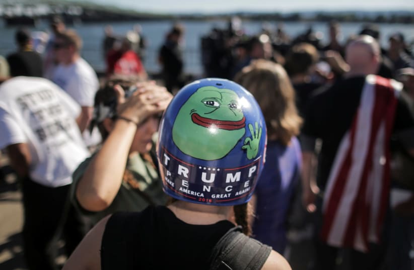 Jaeda Ferrel wears helmet with an image of Pepe the frog and a Trump/Pence sticker at a rally by Patriot Prayer in Vancouver, 2017. (photo credit: ELIJAH NOUVELAGE / REUTERS)