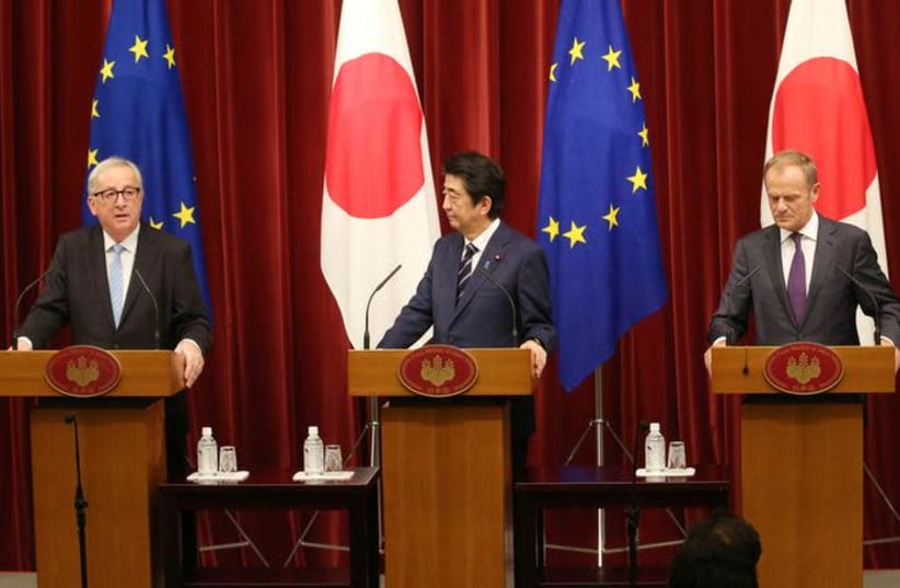 European Commission President Jean-Claude Juncker, left, speaks as Japanese Prime Minister Shinzo Abe, center, and European Council President Donald Tusk, right, listen during a joint press conference of Japan-EU summit at Abe's official residence in Tokyo, Tuesday, July 17, 2018 (photo credit: REUTERS)