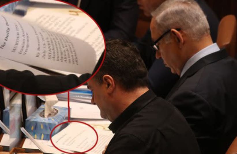 Prime Minister Benjamin Netanyahu reads in the Knesset plenum, July 17th, 2018 (photo credit: LADAAT WEBSITE)