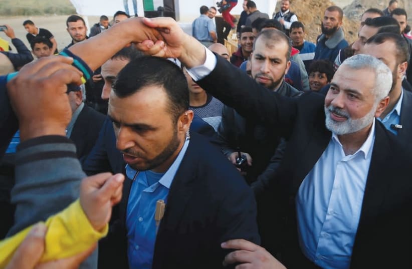 HAMAS CHIEF Ismail Haniyeh shakes hands with a boy during a protest at the Gaza border on April 9, 2018 (photo credit: REUTERS)