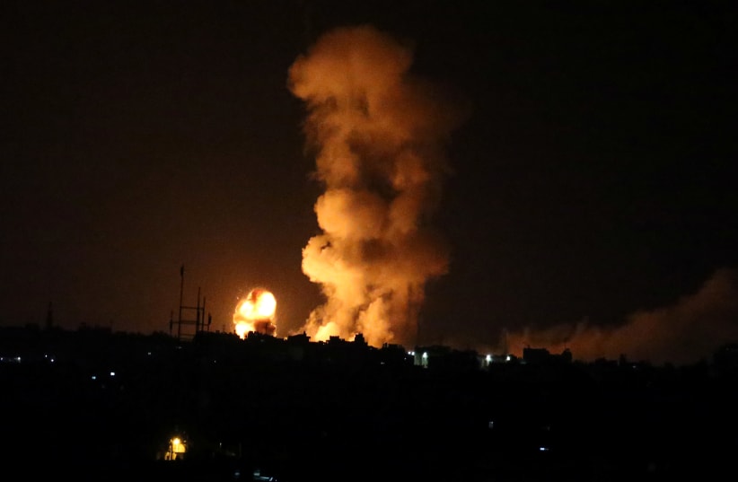 An explosion is seen following an Israeli air strike in the southern Gaza Strip July 20, 2018 (photo credit: IBRAHEEM ABU MUSTAFA / REUTERS)