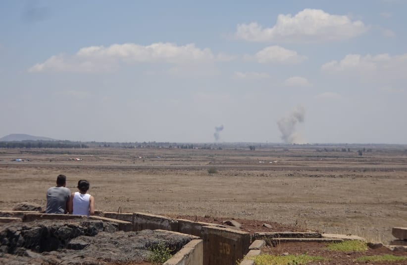 A couple watches the fighting in Syria from Tel Saqi. The Syrian regime and its Russian backers launched numerous artillery and air strikes on ISIS positions 2018 (photo credit: SETH J. FRANTZMAN)