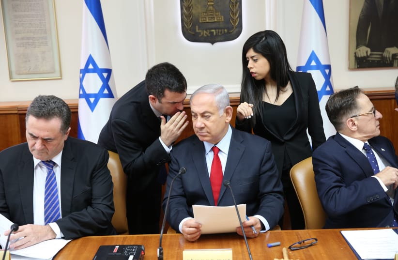 Prime Minister Benjamin Netanyahu whispering in a cabinet meeting on July 23, 2018 (photo credit: ALEX KOLOMOISKY / POOL)