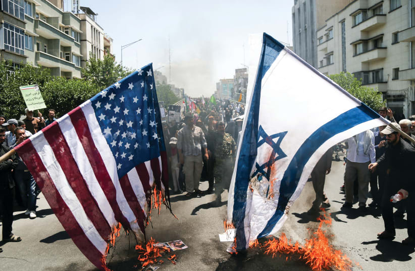IRANIANS BURN US and Israeli flags during a protest in Tehran in June (photo credit: TASNIM NEWS AGENCY/HANDOUT VIA REUTERS)