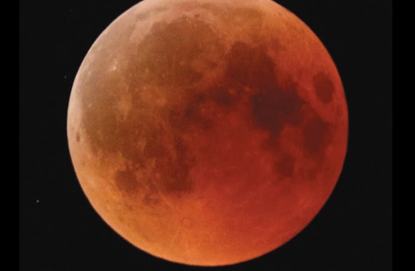 A blood moon rises, as seen from the Israeli city of Ashkelon, on July 27, 2018 (photo credit: AMIR COHEN/REUTERS)