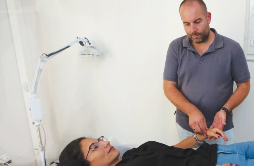 Oz Levy treats a patient (photo credit: MARC ISRAEL SELLEM)