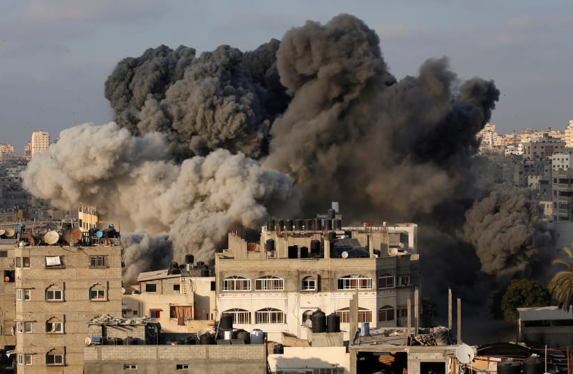 Smoke rises after an Israeli aircraft bombed a multi-story building in Gaza City August 9, 2018 (photo credit: REUTERS/MOHAMMED SALEM)
