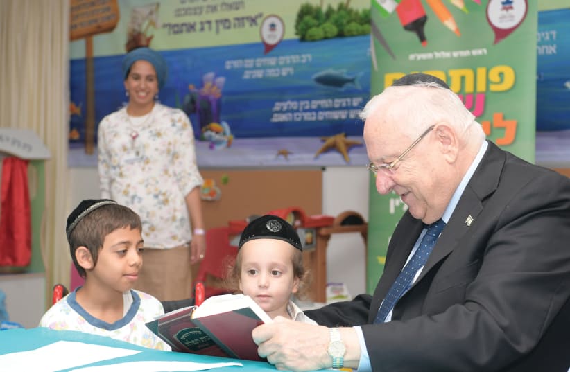 PRESIDENT REUVEN RIVLIN reads with young students taking classes at Mayanei Hayeshua Medical Center in Bnei Brak (photo credit: AMOS BEN GERSHOM, GPO)