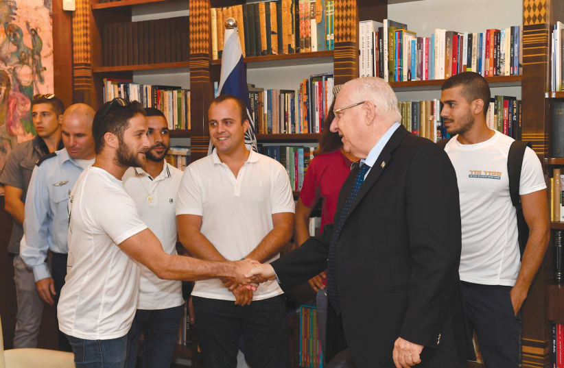 PRESIDENT REUVEN Rivlin meets with comrades in arms of the two soldiers whose bodies are still being held by Hamas.  (photo credit: KOBI GIDEON/GPO)