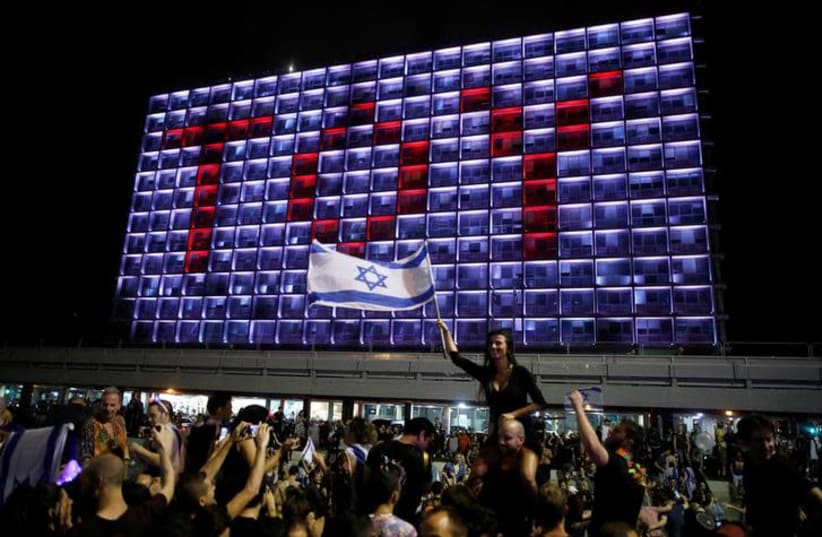 People celebrate the winning of the Eurovision Song Contest 2018 by Israel's Netta Barzilai with her song "Toy" , at Rabin square in Tel Aviv, Israel, May 13, 2018 (photo credit: REUTERS/CORINNA KERN)