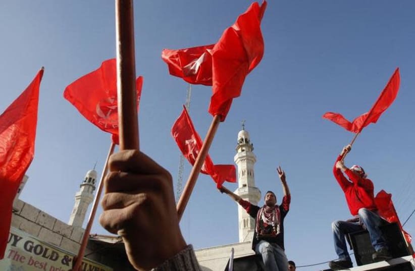 Palestinians take part in a rally organized by the Popular Front for the Liberation of Palestine (PFLP) to celebrate the 43rd anniversary of its founding in the West Bank city of Ramallah December 18, 2010 (photo credit: REUTERS/MOHAMAD TOROKMAN)