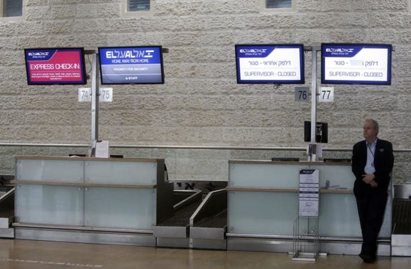 A security officer stands near closed El Al check-in counters in the departure hall at Israel's Ben-Gurion International Airport near Tel Aviv (photo credit: REUTERS/NIR ELIAS)