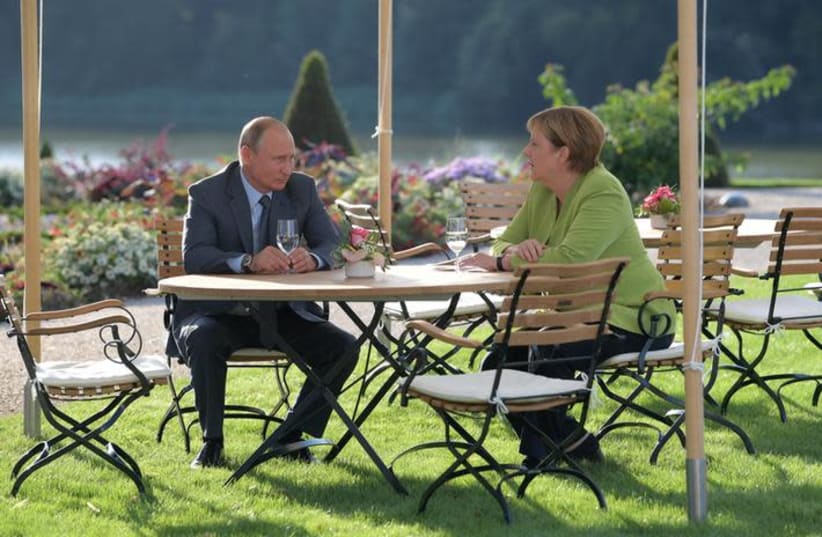 German Chancellor Angela Merkel and Russian President Vladimir Putin speak during their meeting at the German government guest house Meseberg Palace in Gransee, Germany August 18, 2018 (photo credit: SPUTNIK PHOTO AGENCY / REUTERS)