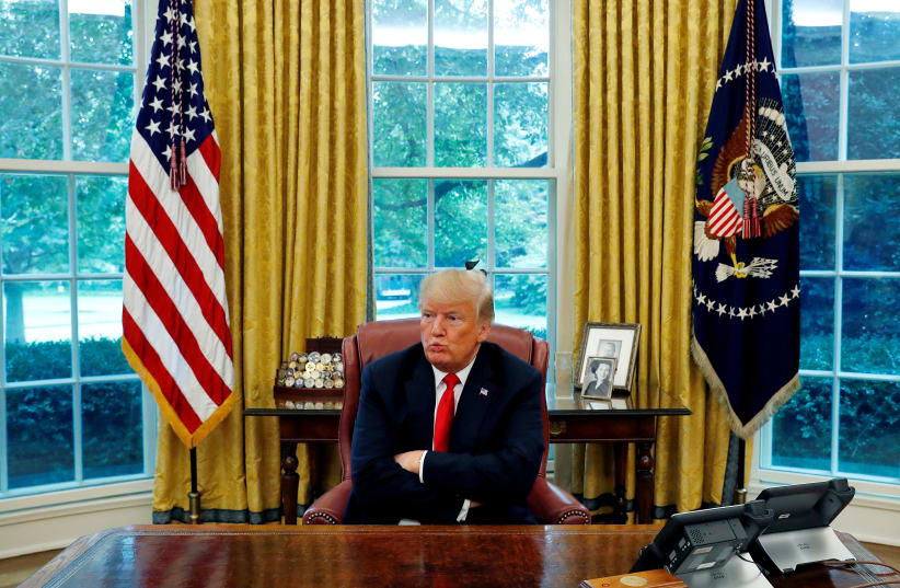US President Donald Trump reacts to a question during an interview with Reuters in the Oval Office of the White House in Washington, US, August 20, 2018 (photo credit: LEAH MILLIS/REUTERS)