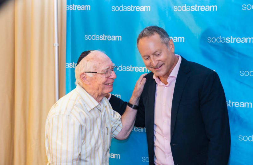 SodaStream CEO Daniel Birnbaum congratulated by his father, Rabbi  Ervin Birnbaum, at Monday's press conference in which Birnbaum announced that he had sold the company to PepsiCo (photo credit: LENS PRODUCTIONS)