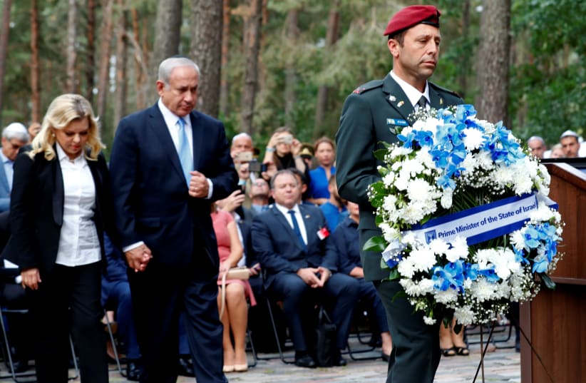 Prime Minister Benjamin Netanyahu and his wife Sara Netanyahu attend the commemoration of victims and award ceremony of the Righteous Among the Nations at the Paneriai Memorial in Vilnius, Lithuania August 24, 2018. (photo credit: INTS KALNINS / REUTERS)