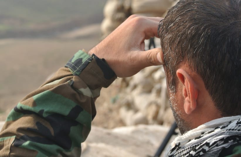 A PAK member looks out over a frontline during the war on ISIS in Iraq in 2016. (photo credit: SETH J. FRANTZMAN)