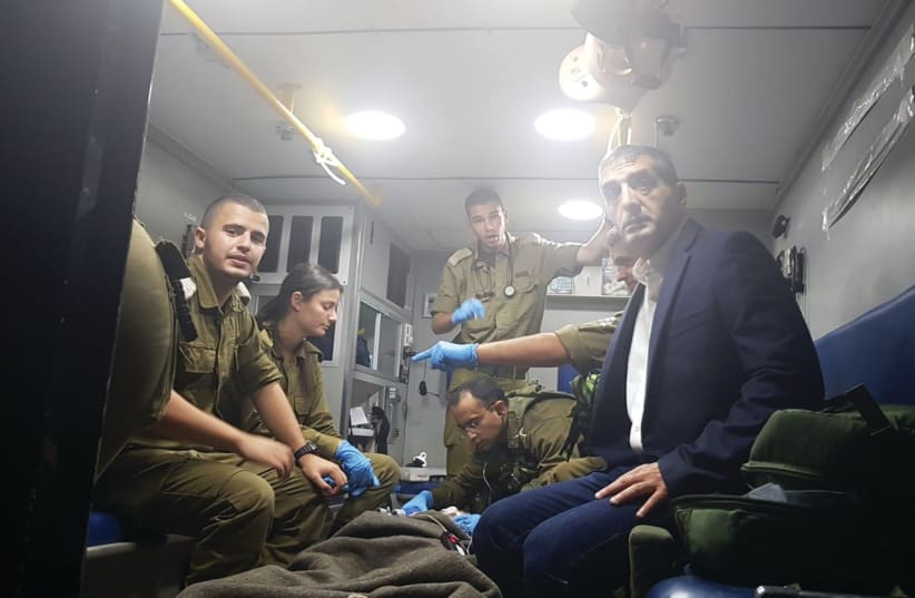 SHEBA MEDICAL CENTER Director General, Prof. Yitshak Kreiss and IDF combat medics transport a severely wounded Syrian child to Sheba Medical Center (photo credit: COURTESY - SHEBA MEDICAL CENTER)