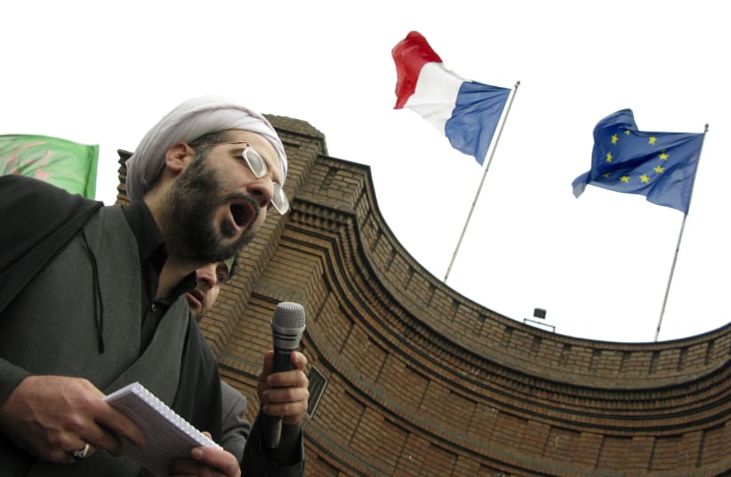 A cleric speaks in front of the French embassy in Tehran during a protest  (photo credit: REUTERS/MORTEZA NIKOUBAZL)