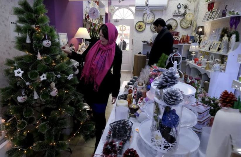 An Iranian Christian woman looks at a Christmas tree at a shop in central Tehran December 23, 2015 (photo credit: RAHEB HOMAVANDI/TIMA VIA REUTERS)