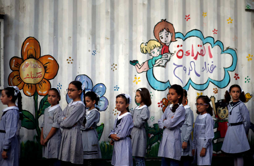 Palestinian schoolgirls queue at an UNRWA-run school, on the first day of a new school year, in Gaza City August 29, 2018 (photo credit: REUTERS/MOHAMMED SALEM)
