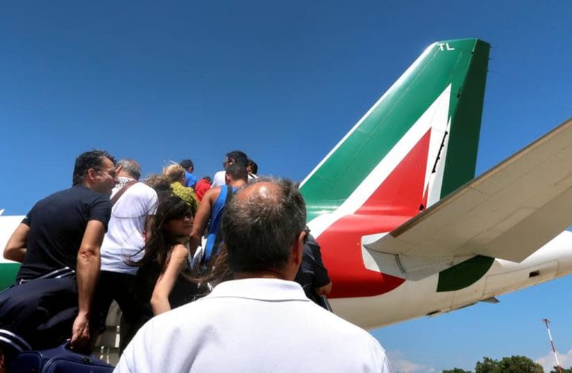 Passengers board an Alitalia airplane at Cagliari airport, Italy, July 9, 2018 (photo credit: STEFANO RELLANDINI/ REUTERS/ FILE PHOTO)