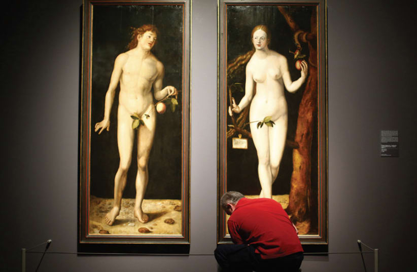 A museum worker cleans the floor in front of the paintings ‘Adam’ and ‘Eve’ by Hans Baldung Grien, the apprentice of German Renaissance painter Albrecht Dürer, at the Staedel Museum in Frankfurt (photo credit: REUTERS/KAI PFAFFENBACH)