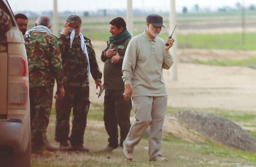 IRANIAN REVOLUTIONARY Guards Corps commander Qassem Soleimani uses a walkie-talkie at the frontlines during offensive operations against Islamic State, in Salahuddin province in 2015 (photo credit: REUTERS)