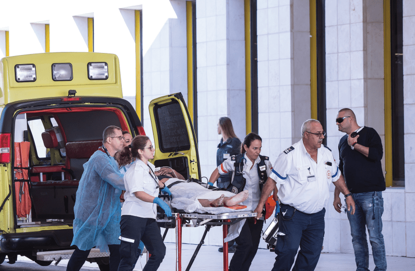 Assuta staff rush a patient to the hospital through its emergency entrance (photo credit: ODED KARNI)