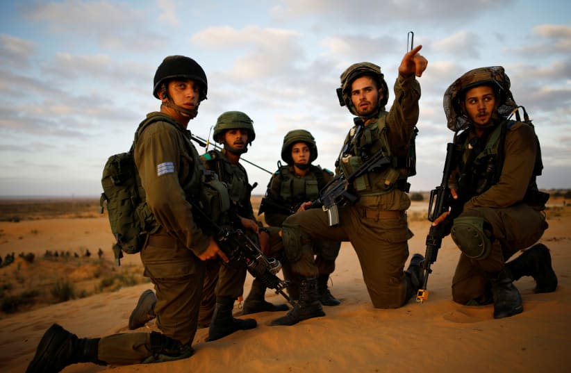 Israeli soldiers from the Home Front Command Unit gather as they take part in an urban warfare drill inside a mock village at Tze'elim army base in Israel's Negev Desert June 11, 2017. Picture taken June 11, 2017.  (photo credit: AMIR COHEN/REUTERS)