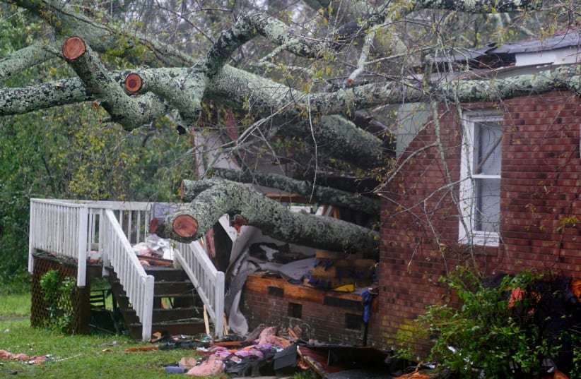 A house where, according to local media, a woman and her child died as a result of a downed tree is pictured as Hurricane Florence comes ashore in Wilmington, North Carolina, U.S., September 14, 2018. (photo credit: CARLO ALLEGRI/REUTERS)