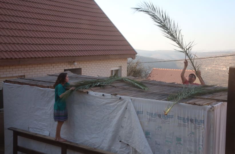 Building a sukkah in Ma'aleh Levona (photo credit: MARC ISRAEL SELLEM/THE JERUSALEM POST)