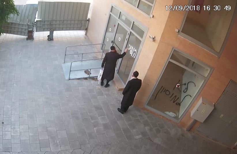Haredi men caught on security camera spray painting the Beit Hallel Congregation building on September 12 2018   (photo credit: ISRAEL POCHTAR)